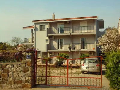 a building with a car parked in front of a gate at Apartments Macaso in Bar