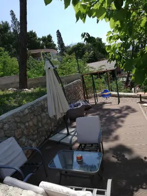 a patio with a table and an umbrella and chairs at Grlica in Bar