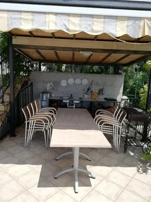 a table and chairs on a patio with a kitchen at Grlica in Bar