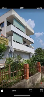 a white building with a fence in front of it at Apartman Andrea in Bar