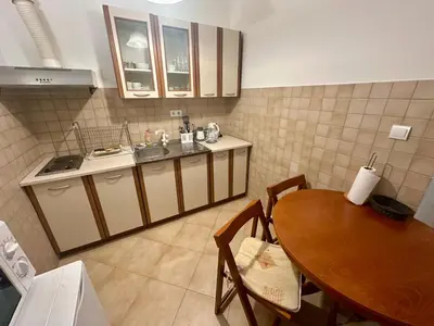 a kitchen with a table and a sink and a table and chairs at Apartment Caramel Petrovac in Petrovac na Moru
