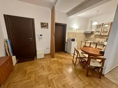 a living room with a table and a kitchen at Apartment Caramel Petrovac in Petrovac na Moru