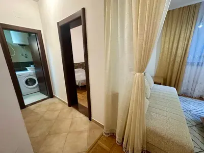 a bedroom with a mirror and a bed and a washing machine at Apartment Caramel Petrovac in Petrovac na Moru