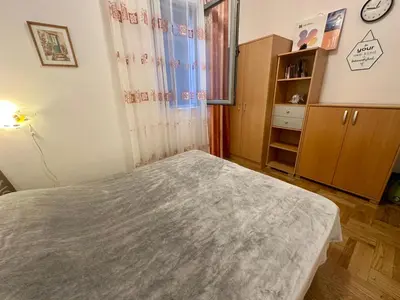 a small bedroom with a bed and a window at Apartment Caramel Petrovac in Petrovac na Moru