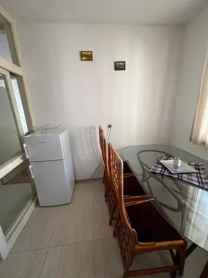 a kitchen with a glass table and a refrigerator at Sutomore Centar in Sutomore