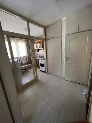 an empty room with a door and a kitchen at Sutomore Centar in Sutomore