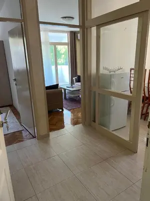 a living room with sliding glass doors and a kitchen at Sutomore Centar in Sutomore