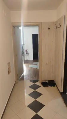 an empty room with a checkered floor and a hallway at V&J apartments in Podgorica