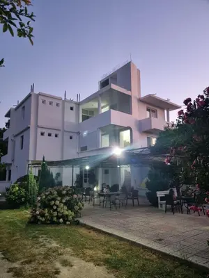 a large building with tables and chairs in front of it at Casa Gazi in Ulcinj