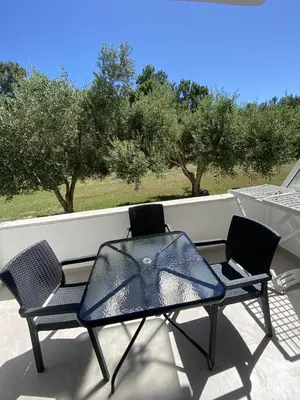 two chairs and a table on a porch with trees at Casa Gazi in Ulcinj