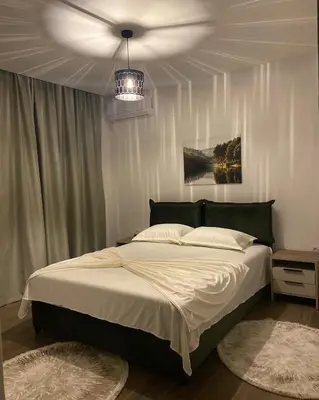 a bedroom with a large bed and a chandelier at Casa Gazi in Ulcinj