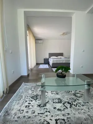 a living room with a glass table and a bed at Casa Gazi in Ulcinj