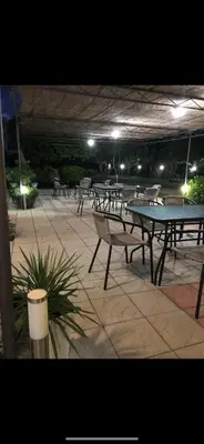 a group of tables and benches on a patio at night at Casa Gazi in Ulcinj