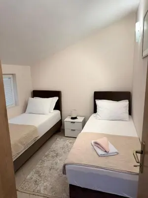 two beds in a small room with two bedsskirts at Goga Apartment in Kotor