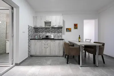 a kitchen and dining room with a table and chairs at Petrovac Holiday Apartments 2 in Petrovac na Moru