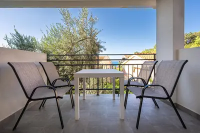 a table and chairs on a balcony with a view at Petrovac Holiday Apartments 2 in Petrovac na Moru