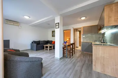 a kitchen and living room with a couch and a table at Petrovac Holiday Apartments 2 in Petrovac na Moru