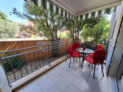 a balcony with red chairs and a table on a balcony at Ljiljana in Petrovac na Moru