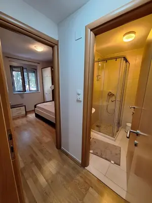 a bathroom with a shower and a door to a bedroom at Ljiljana in Petrovac na Moru