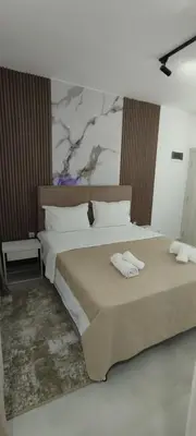a bedroom with two beds and a painting on the wall at Kahari Apartments in Ulcinj