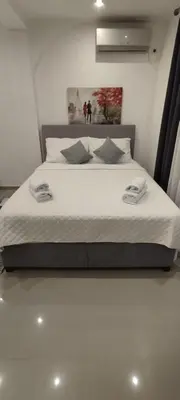 a bed with white sheets and pillows in a room at Kahari Apartments in Ulcinj