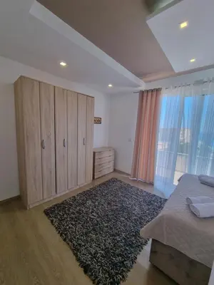 a bedroom with a bed and a wardrobe and a rug at Kahari Apartments in Ulcinj