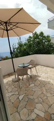 a table and chairs with an umbrella on a patio at Kahari Apartments in Ulcinj