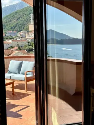 a view of the water from a window with a couch at PalmOliva in Rafailovici