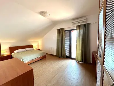 a bedroom with a bed and a large window at PalmOliva in Rafailovici