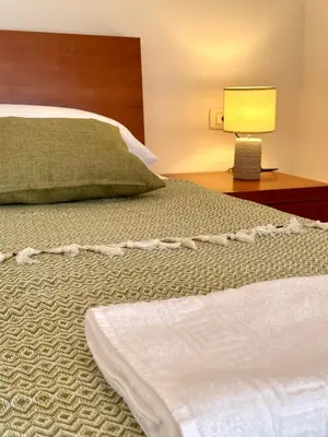 a bed in a hotel room with a white bedspread at PalmOliva in Rafailovici