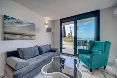 a living room with a couch and a chair at Sea Salt Apartment in Kruče