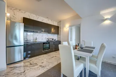 a kitchen with a table and a stainless steel refrigerator at Sea Salt Apartment in Kruče
