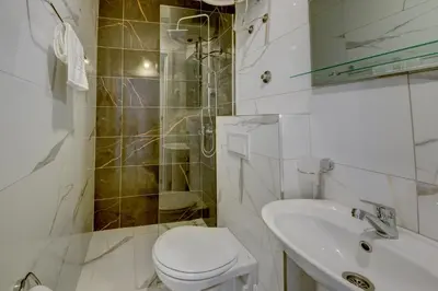 a white bathroom with a toilet and a sink at Sea Salt Apartment in Kruče