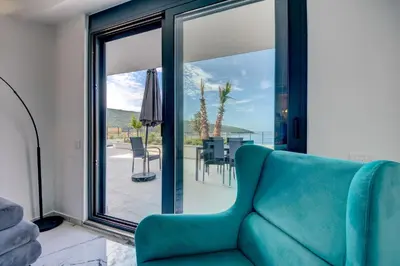 a living room with a blue couch and a patio at Sea Salt Apartment in Kruče