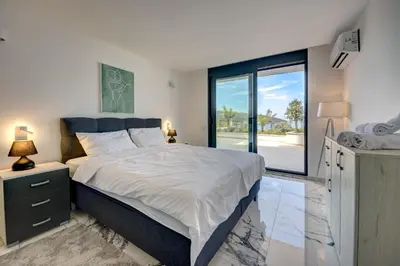 a bedroom with a large bed and a large window at Sea Salt Apartment in Kruče