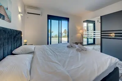 a bedroom with a bed with two stuffed animals on it at Sea Salt Apartment in Kruče