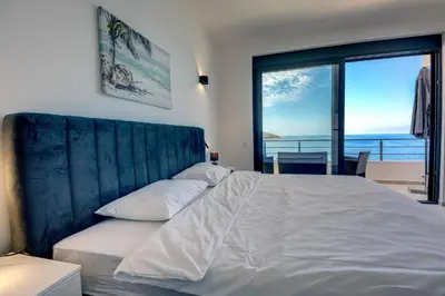 a bedroom with a bed with a view of the ocean at Sea Breeze Apartment in Kruče