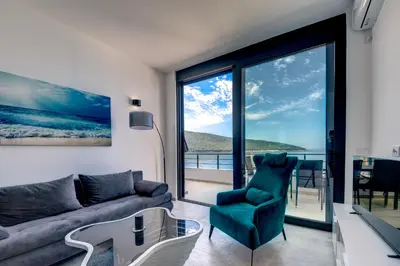 a living room with a couch and a table and chairs at Sea Wave Apartment in Kruče