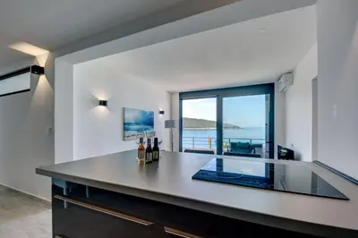 a kitchen with a counter with a view of the ocean at Sea Wave Apartment in Kruče