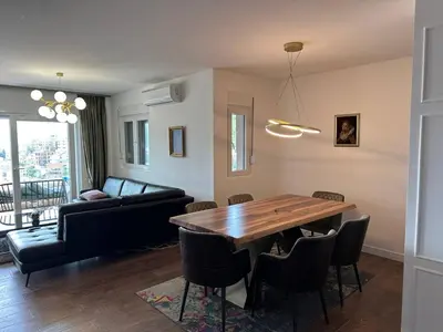 a living room with a wooden table and a couch at Penthouse NIKOLA in Budva