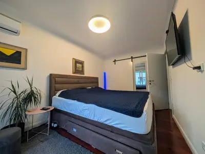 a bedroom with a bed and a flat screen tv at Penthouse NIKOLA in Budva