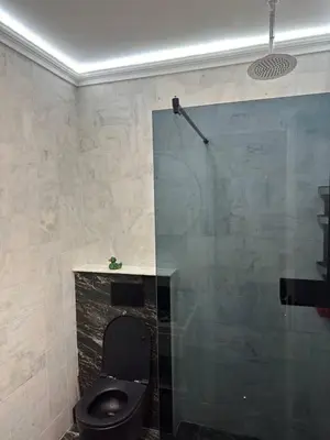 a bathroom with a black toilet and a glass wall at Penthouse NIKOLA in Budva
