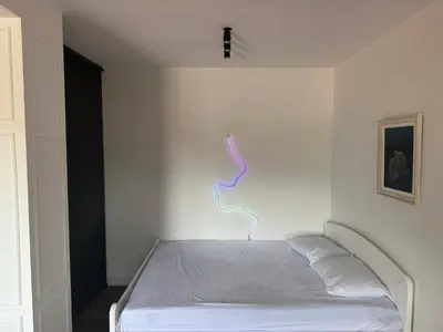 a bedroom with a bed with a light on the wall at Penthouse NIKOLA in Budva