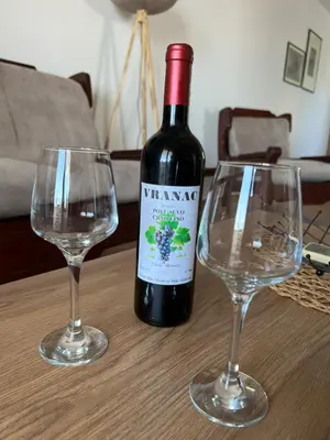 a bottle of wine and two wine glasses on a table at Apartments Andrović in Ulcinj
