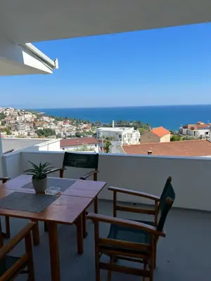 a balcony with tables and chairs and a view of the ocean at Apartments Andrović in Ulcinj