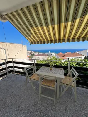 a table and chairs on a balcony with a view of the ocean at Apartments Andrović in Ulcinj