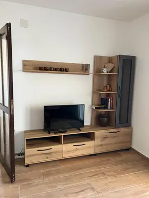 a wooden entertainment center with a flat screen tv at Apartments Andrović in Ulcinj