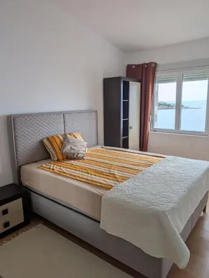 a bedroom with a large bed with a window at Vila Anja in Dobra Voda