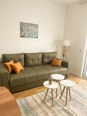 a living room with a green couch and two tables at Le Vacanze in Ulcinj
