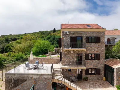 a stone house with a balcony and a patio at Villa Jovana in Zagora